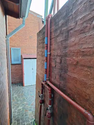 Bobinas sobre el caño vertical de bajada, en un pasillo exterior.